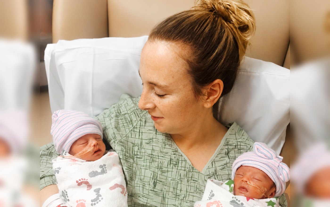 A mother holding her newborn twins